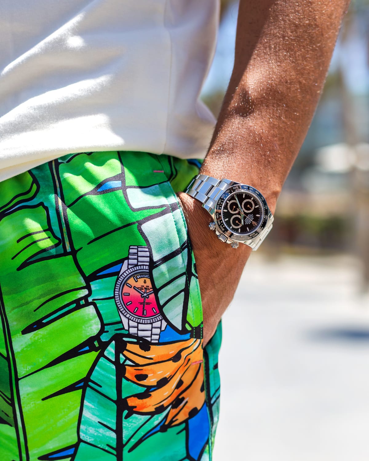 Leopine Palm o’Clock swim shorts, hand-drawn banana leaves and a coloured dial, worn with a steel chronograph
